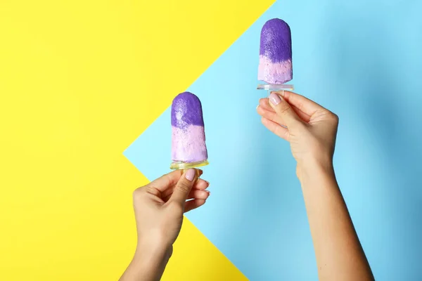 Female hands with tasty blueberry ice cream on color background — Stock Photo, Image