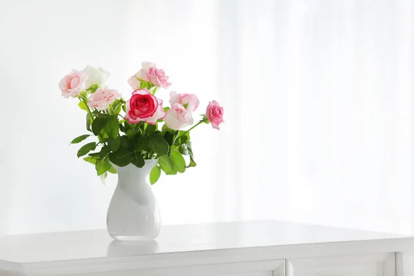 Beautiful rose flowers in vase on table in room — ストック写真