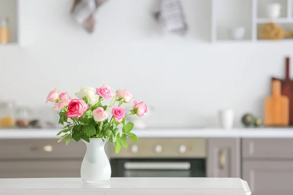 Mooie roos bloemen in vaas op tafel in de keuken — Stockfoto