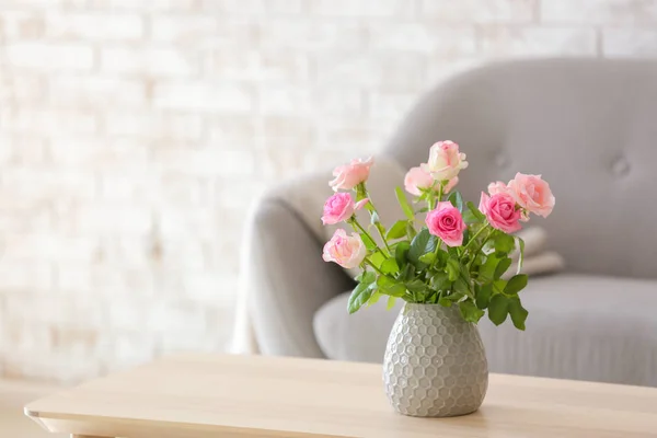 Lindas flores de rosa em vaso na mesa no quarto — Fotografia de Stock