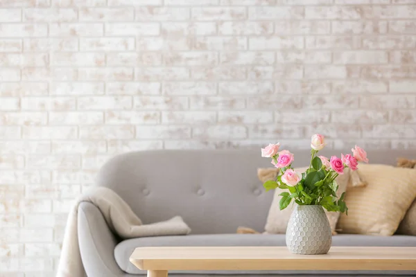 Hermosas flores de rosa en jarrón en la mesa en la habitación — Foto de Stock