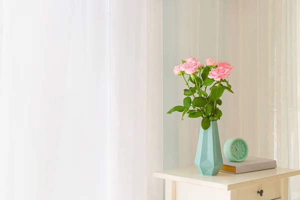 Piękne kwiaty róży w wazonie na stole w pobliżu okna — Zdjęcie stockowe