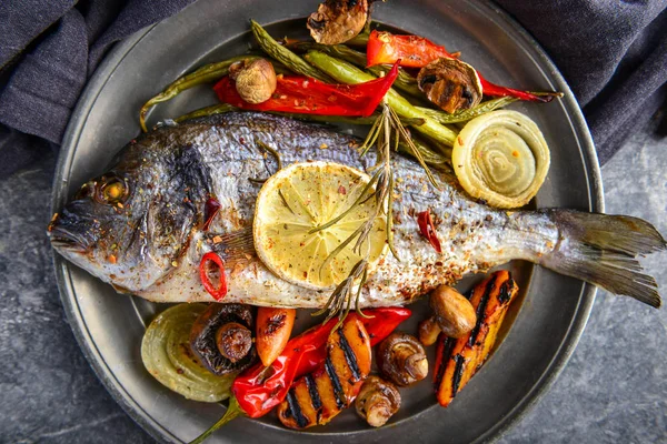 Assiette avec poisson dorado préparé et légumes sur la table — Photo