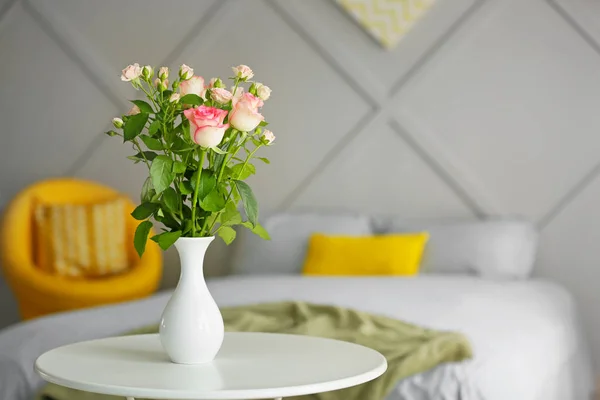 Vase with beautiful rose flowers on table in bedroom — ストック写真