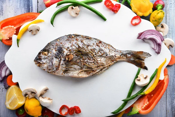 Prepared dorado fish and fresh vegetables on board, top view — Stock Photo, Image