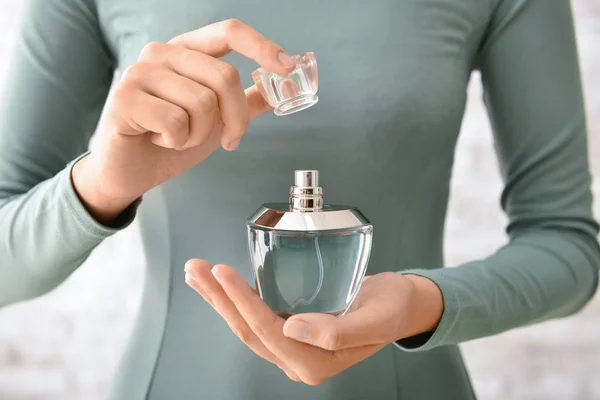 Mujer joven con botella de perfume en casa, primer plano — Foto de Stock