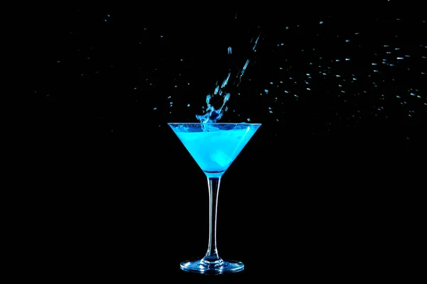 Стакан вкусного коктейля с брызгами на темном фоне — стоковое фото