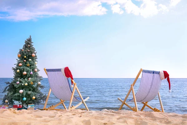 Christmas tree with sun loungers on sea beach — Stock Photo, Image