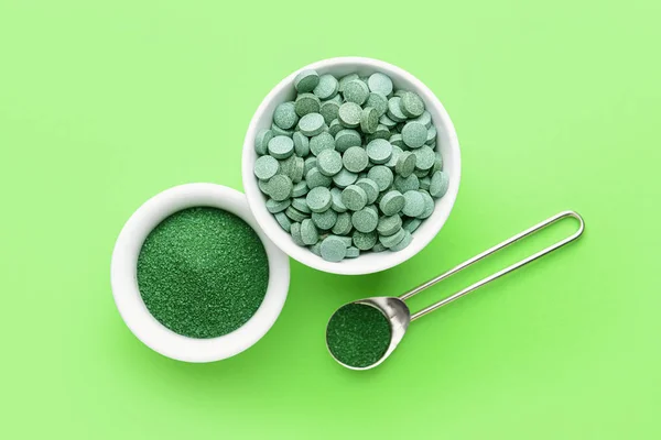 Samenstelling met spirulina poeder en pillen op kleur achtergrond — Stockfoto