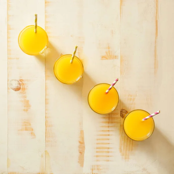 Glasses of fresh orange juice on wooden table — Stock Photo, Image