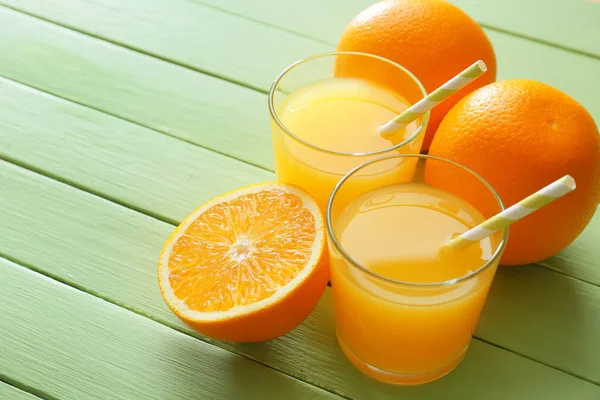 Ποτήρια φρέσκο χυμό πορτοκαλιού στο ξύλινο τραπέζι — Φωτογραφία Αρχείου