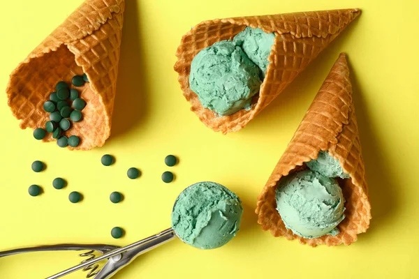 Waffle cones with tasty spirulina ice-cream on color background — Stock Photo, Image