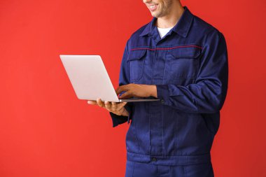 Renkli dizüstü bilgisayarı olan erkek araba tamircisi