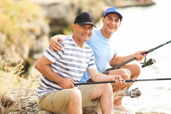 Joven y su padre pescando en el río — Foto de Stock