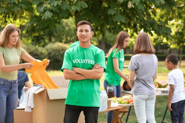 Молодий волонтер з пожертвами для бідних людей на відкритому повітрі — стокове фото