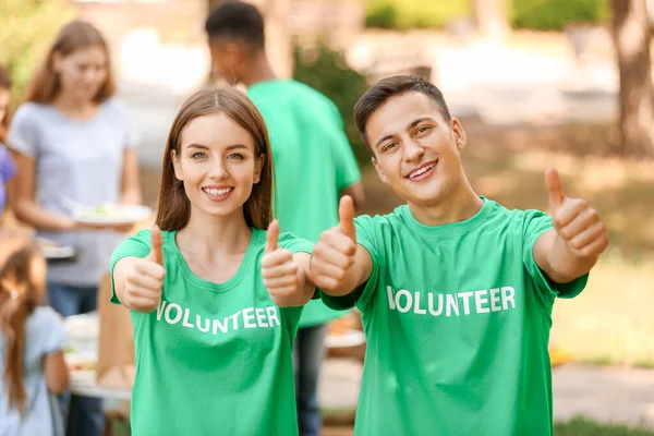 Jonge vrijwilligers tonen duimgebaar buiten — Stockfoto