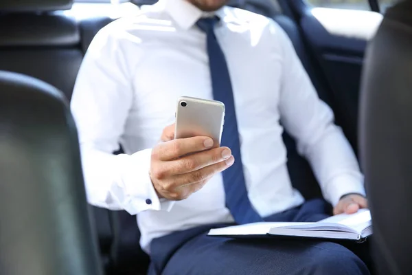 Uomo d'affari di successo con il telefono cellulare in auto moderna — Foto Stock