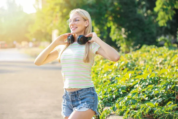 Beautiful young woman with headphones outdoors — Stock Photo, Image