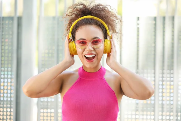 Happy African-American woman listening to music outdoors — Stock Photo, Image