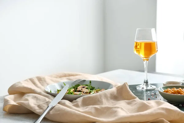 Чаша с вкусным салатом и бокалом вина на столе — стоковое фото