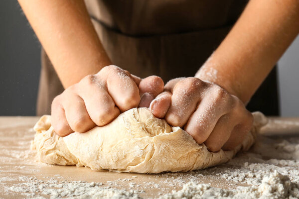 Woman kneading flour in kitchen, closeup