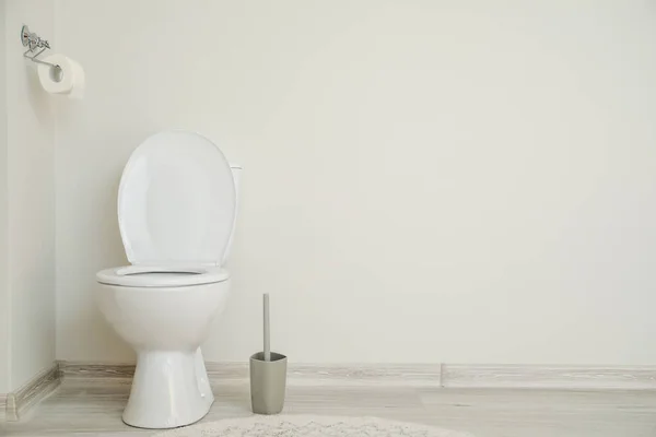 Moderna keramiska toalettstolen nära vita väggen i toalett — Stockfoto