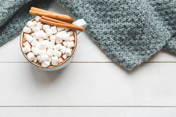 Cup of hot chocolate with marshmallows and plaid on white table — Stock Photo, Image