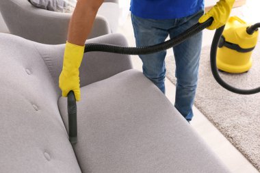 Genç adam dairesini temizliyor.