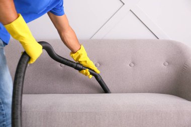 Genç adam dairesini temizliyor.