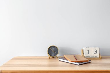 Alarmlı saati, kırtasiyesi ve ışık duvarı yakınında takvimi olan modern iş yeri