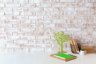 Duvarın yanında kırtasiye malzemesi olan modern işyeri