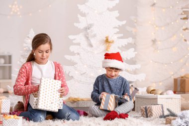 Sevimli küçük kız evde Noel hediyelerini açıyor.