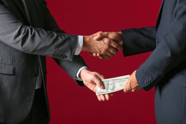 İş adamı renk arkaplanına karşı rüşvet alıyor
