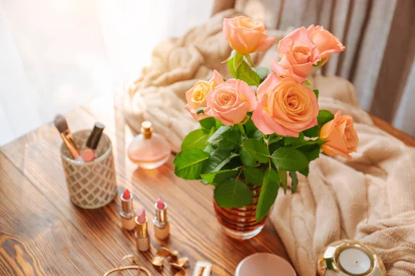 Flores de rosa com cosméticos de maquiagem na mesa de madeira no quarto — Fotografia de Stock