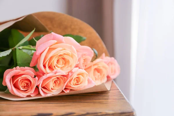 Rose flowers on wooden table in room — Stock Photo, Image