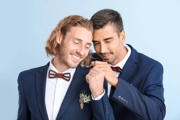 Portrait of happy gay couple on their wedding day against color background — Stock Photo, Image