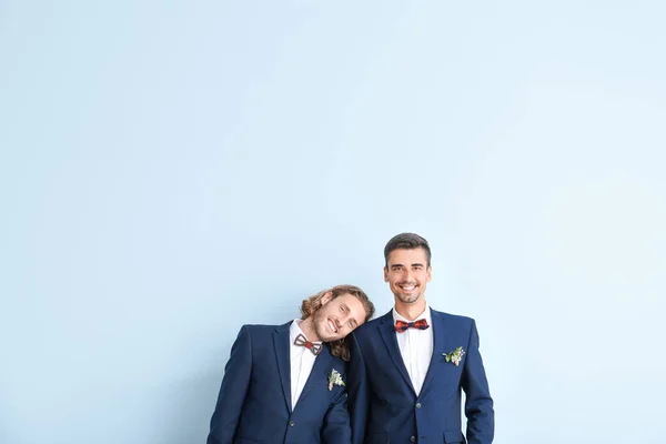 Portrait of happy gay couple on their wedding day against color background — Stock Photo, Image