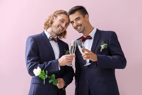 Boldog meleg pár pezsgőt az esküvő napján elleni színes háttér — Stock Fotó