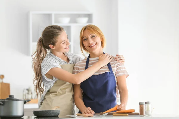 Young woman and her mother cooking together in kitchen — Stock Photo, Image