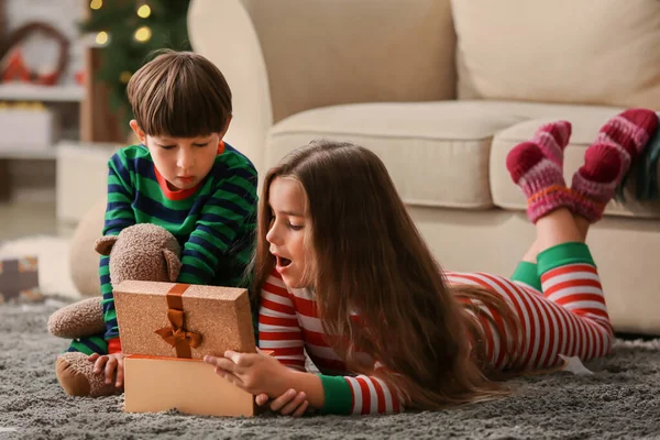 Söta små barn öppnar julklapp hemma — Stockfoto