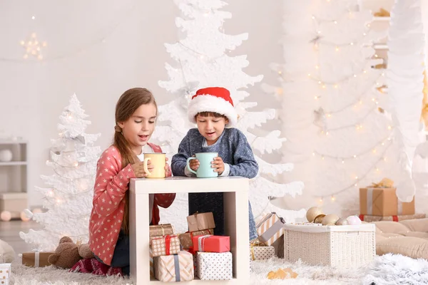 Crianças pequenas bonitos beber chocolate quente na véspera de Natal em casa — Fotografia de Stock
