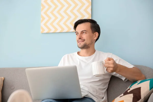 英俊的男人与笔记本电脑在家里喝咖啡 — 图库照片
