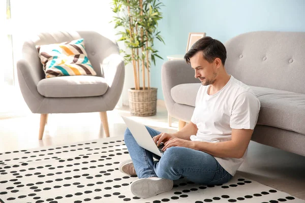 Beau homme avec ordinateur portable reposant à la maison — Photo