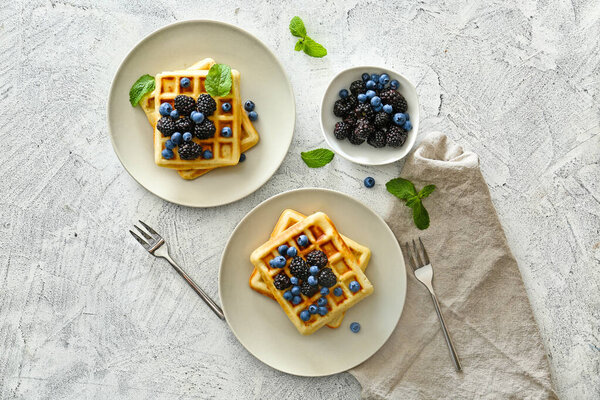 Композиция с вкусными вафлями и ягодами на столе
