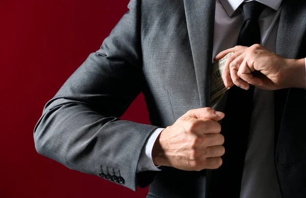 Бизнесмен кладет взятку в карман, крупным планом. Концепция коррупции — стоковое фото