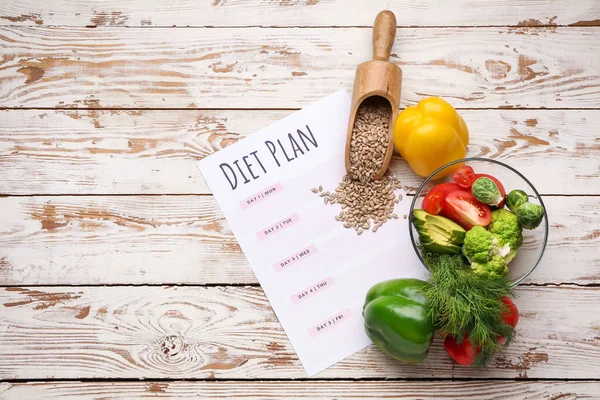 Verschiedene gesunde Lebensmittel mit Diätplan auf Holztisch — Stockfoto
