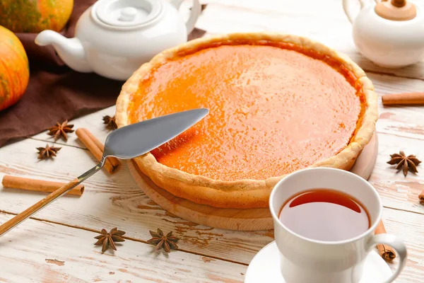 Sabroso pastel de calabaza y taza de té en la mesa de madera — Foto de Stock