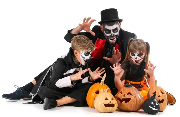 Vater mit Kindern in Halloween-Kostümen und mit Kürbissen auf weißem Hintergrund — Stockfoto