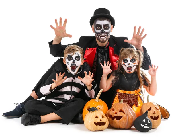 Vater mit Kindern in Halloween-Kostümen und mit Kürbissen auf weißem Hintergrund — Stockfoto