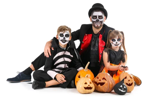 Vater mit Kindern in Halloween-Kostümen und mit Kürbissen auf weißem Hintergrund — Stockfoto